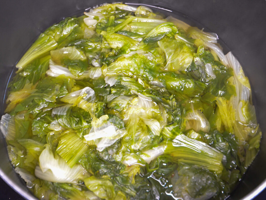 Escarole boiling in a pot, wilted. 